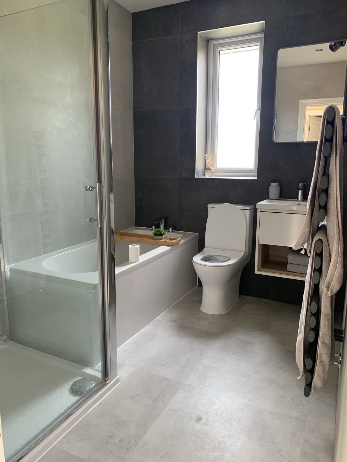 Dark-toned bathroom with bath and separate shower by JMB Plumbing & Heating