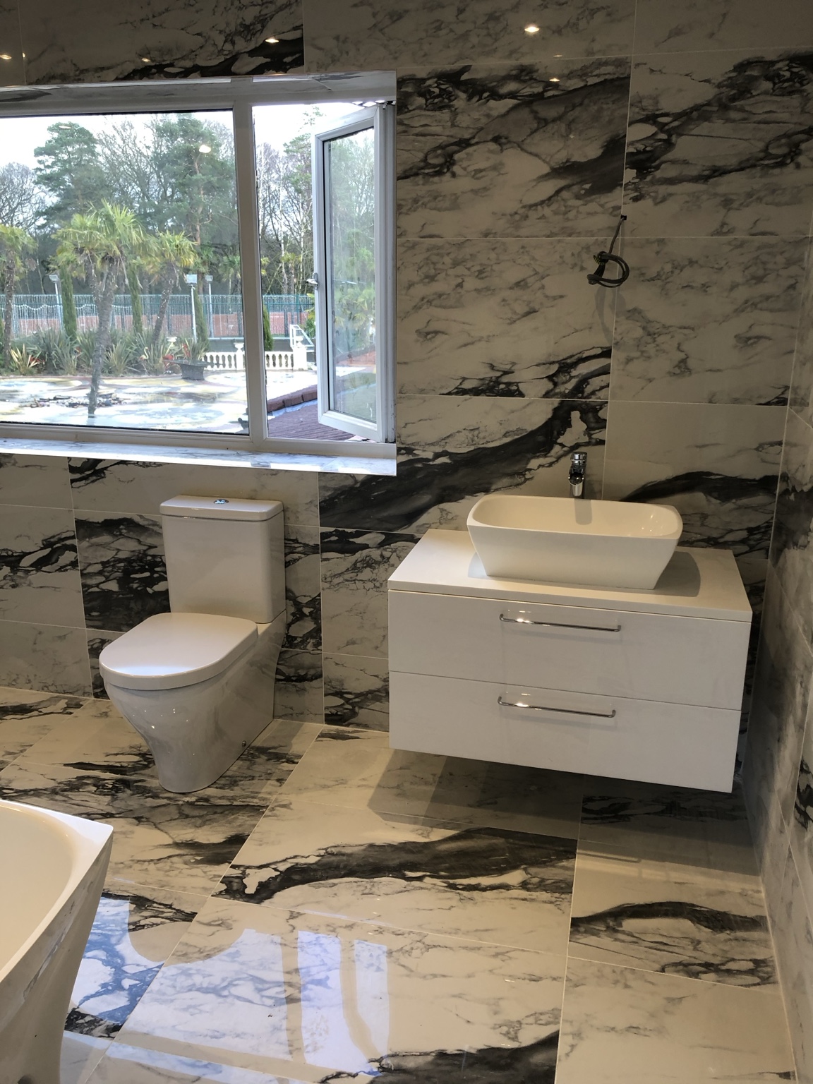 Marble-effect bathroom with wall-hung vanity and sanitaryware
