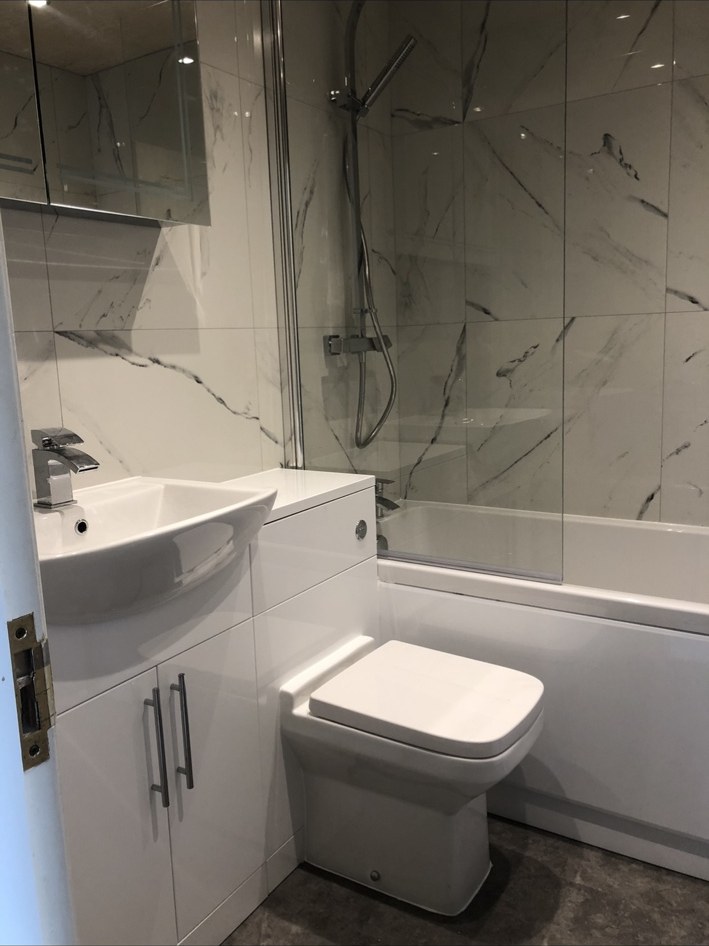 Family bathroom with shower over bath by JMB Plumbing & Heating