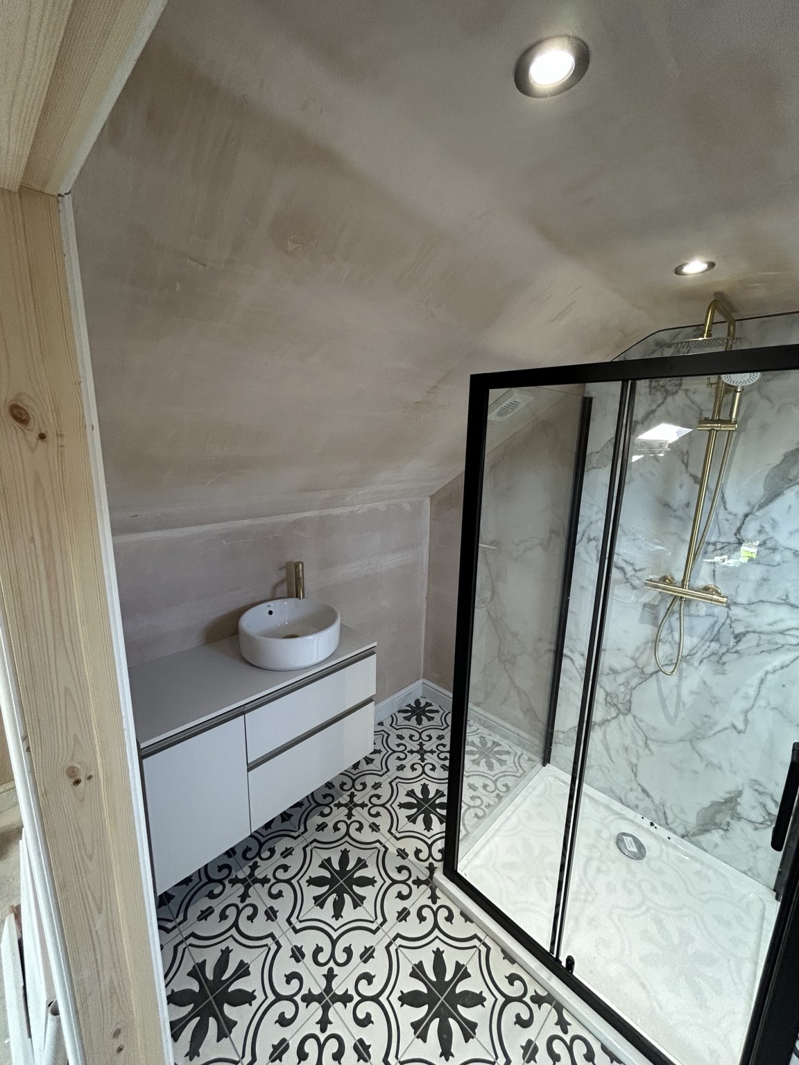 Patterned-floor bathroom with walk-in shower by JMB Plumbing & Heating